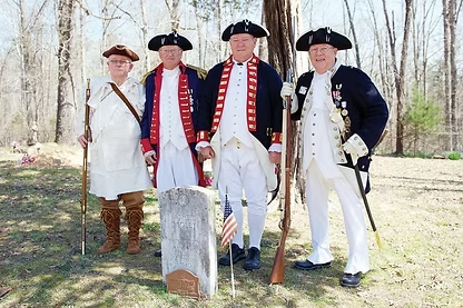 Men in colonial costumes by a grave